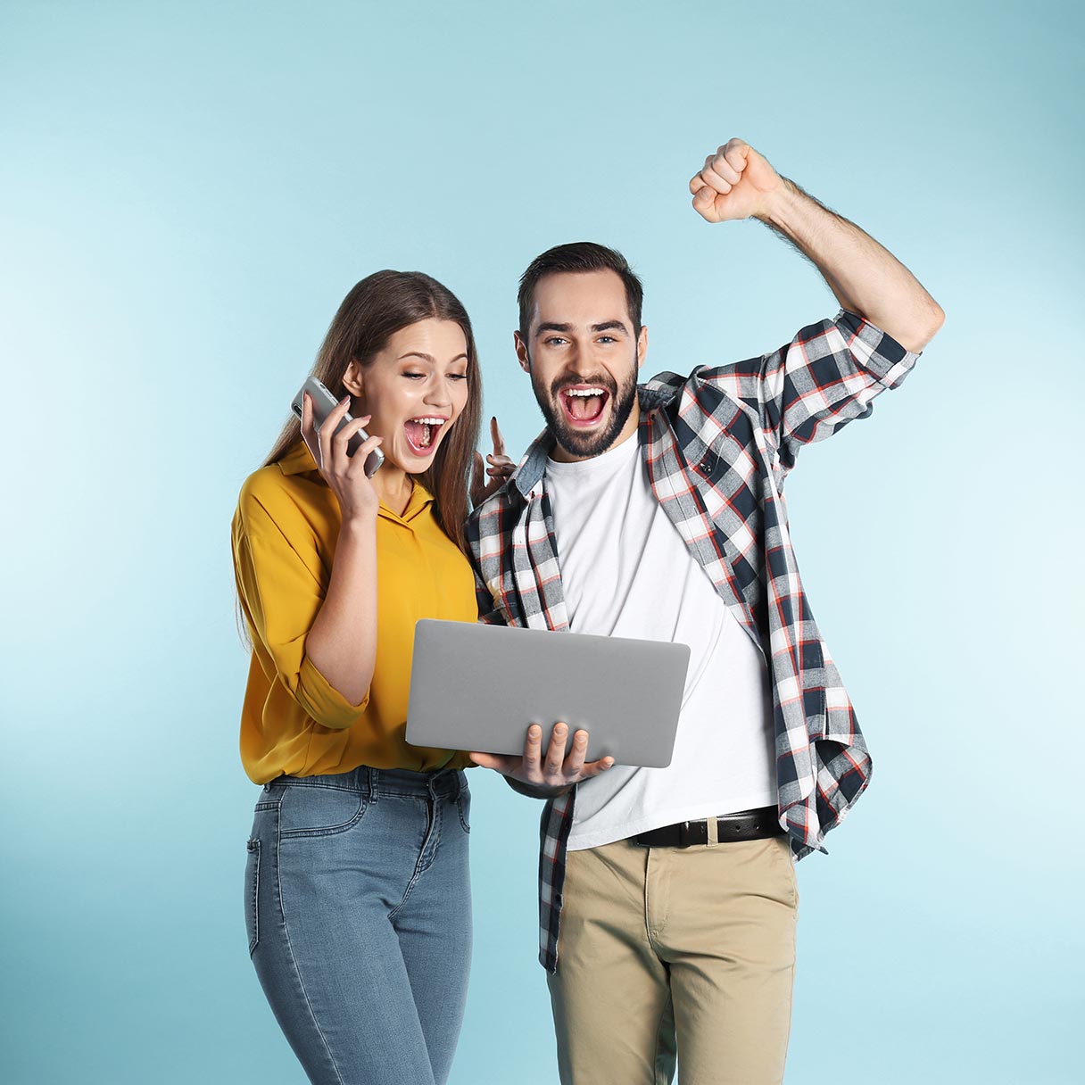 Photo of man and women celebrating as they look at a laptop screen