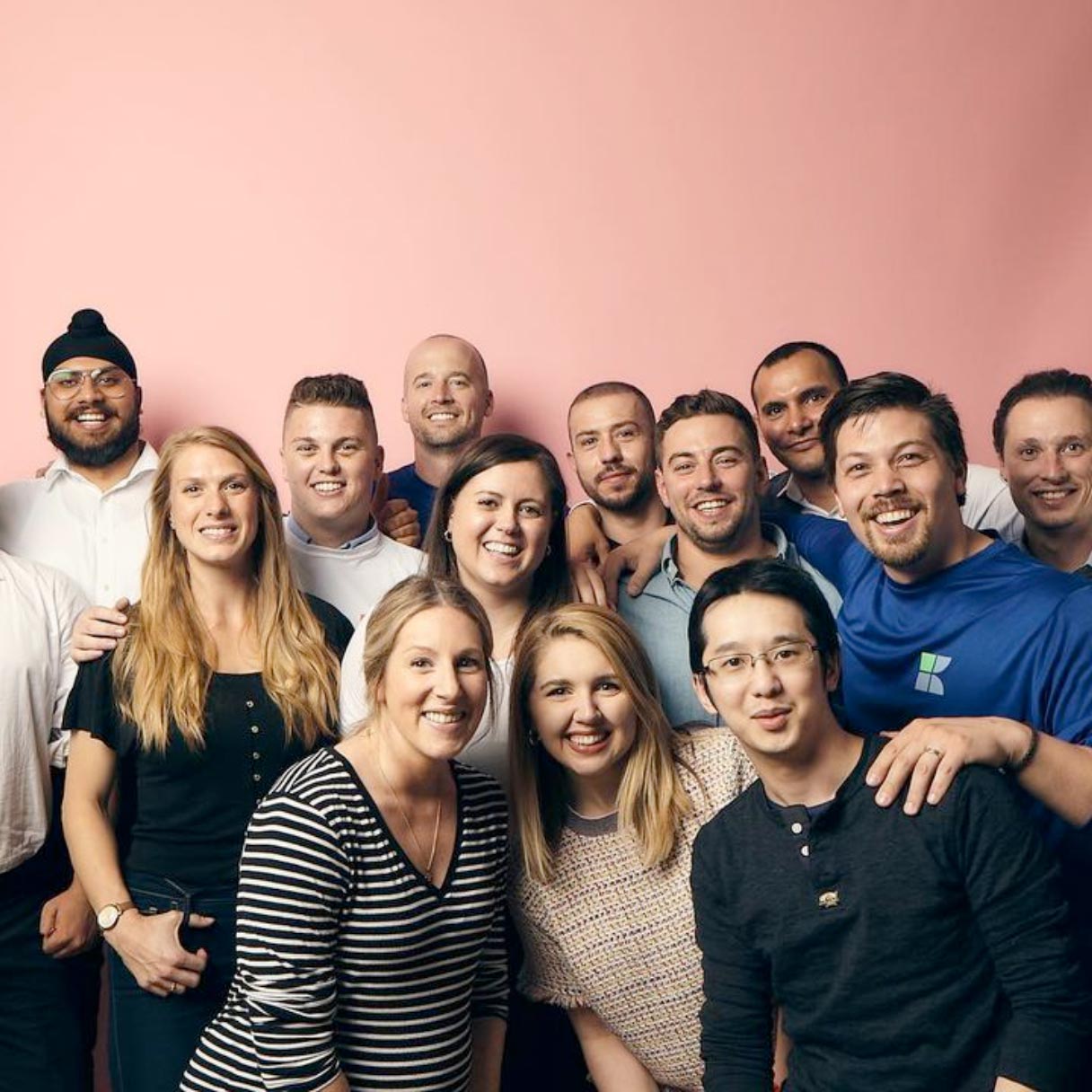 Photo of the kite team smiling infront of pink backdrop